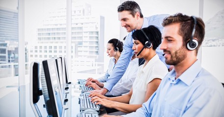 Manager and executives with headsets using computers