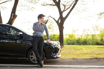 Young businessmen talking on a cell phone broken car On Country Road Phoning For Help