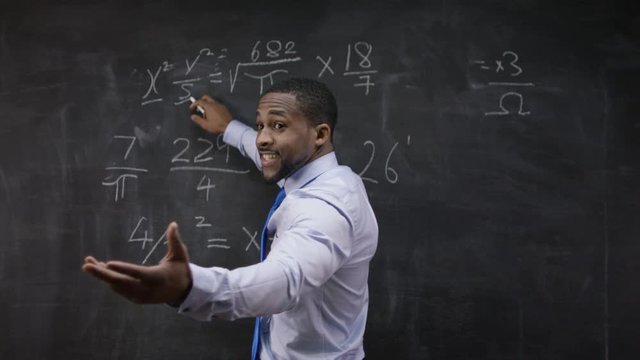  Portrait of man in white coat, standing in front of blank blackboard 