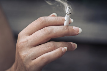 woman holding burning cigarette in hand. smoking woman