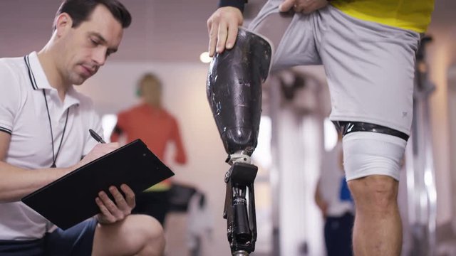  Disabled Athlete At The Gym Puts On Prosthetic Leg To Prepare For Workout