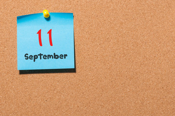 September 11th. Day 11 of month, color sticker calendar on notice board. Autumn time. Empty space for text