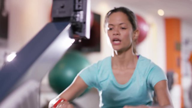  Woman working out on rowing machine at the gym