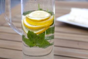 can with water and lemon slices on wooden table