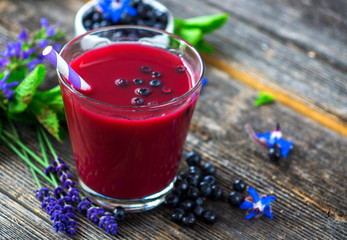 Delicious smoothie with fresh blueberries on a wood background