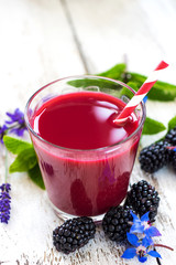 A glass of fresh delicious smoothie of blackberries on wooden background