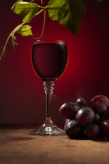 red wine in a glass and ripe grapes