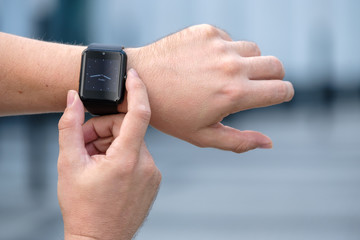 Man using smart watch outdoors