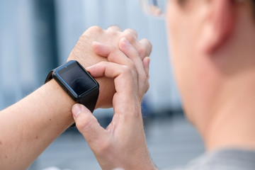 Man using smart watch outdoors