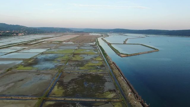 4K. Flight over soline in Slovenia on sunset, place of extraction of sea salt, aerial panoramic view. Secovljske Soline, Slovenia.