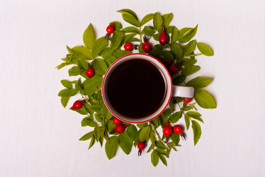 Fototapeta Cup of coffee on a white background in  leaves and red berries.F