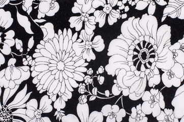 Graphic floral pattern on fabric. Black and white flowers print as background.