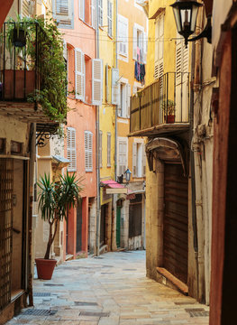 Fototapeta Narrow street with flowers in the old town in France