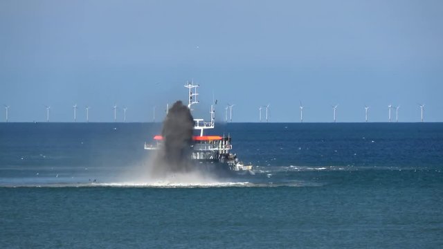 Footage of ship at sea dredging an excavation activity done in shallow water areas for gathering up bottom sediments and disposing of them at different location often used to keep waterways navigable