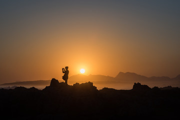 Naklejka premium Persona osserva il tramonto sul mare