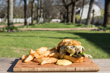 Hamburger e patatine fritte  sul tagliere di legno