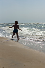 Fototapeta na wymiar the little boy frolics at the sea