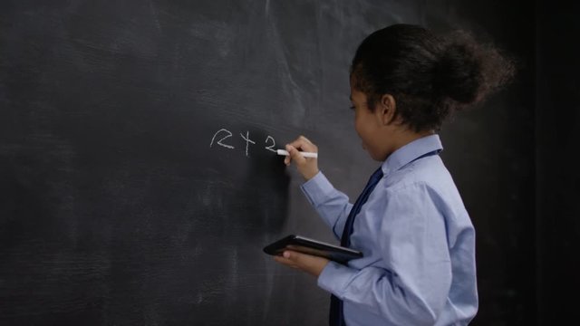  Portrait of thinking man sitting in front of blackboard with math formulas