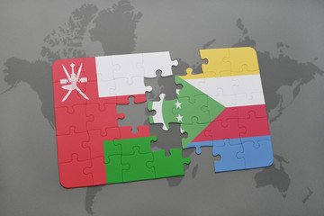 puzzle with the national flag of oman and comoros on a world map background.