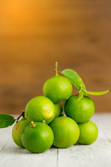 Fototapeta na wymiar green lemon on white wooden