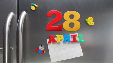 April 28 calendar date made with plastic magnetic letters holding a note of graph paper on door refrigerator