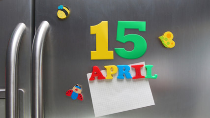 April 15 calendar date made with plastic magnetic letters holding a note of graph paper on door...