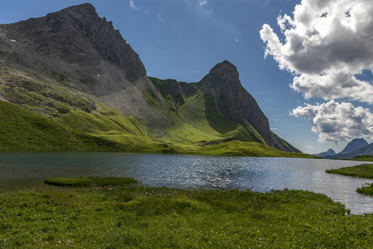 Kleiner See mit Bergen und blauem Himmel