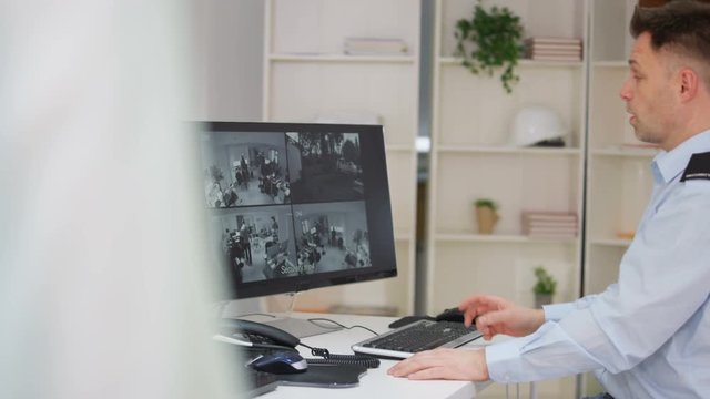  Security worker in system control room gets caught out watching TV on screen.