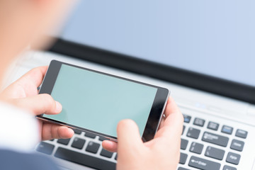 Businessman using smart phone and laptop.