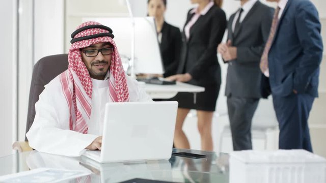  Portrait smiling Arabic businessman with business team in background