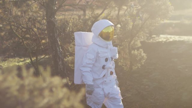  Astronaut walking in woodland area looking for signs of life