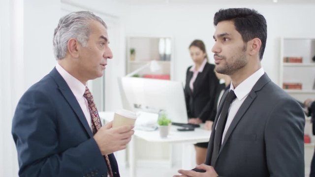  Arab businessmen having a serious conversation in office