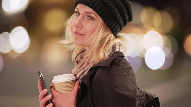 Happy Woman textingon smartphone while waiting for taxi