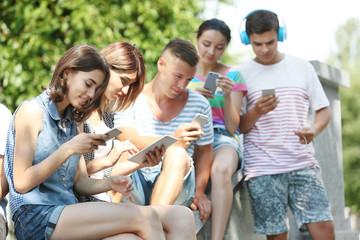 Teenagers with gadgets on street