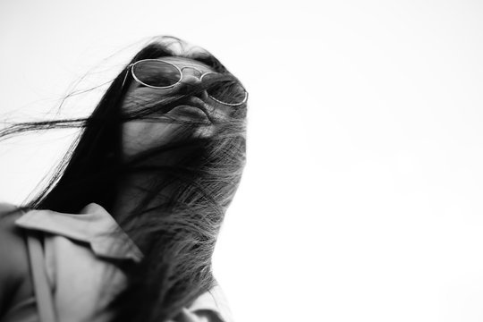 black and white portrait young asian woman with sunglass and her hair is blow,and eyey view,selective focus