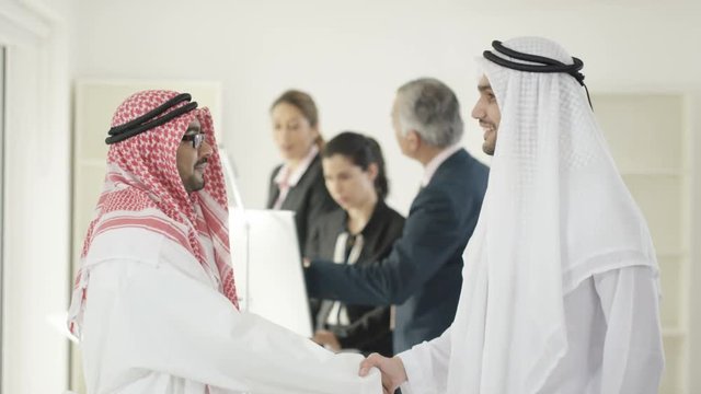  Portrait of smiling Arab businessmen meeting & shaking hands