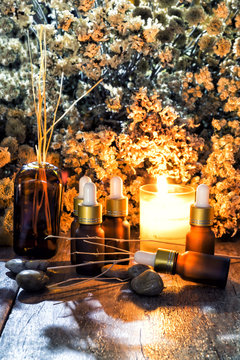 Bottles of organic aromatherapy essential oils with dry flowers