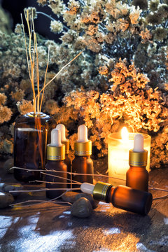 Bottles of organic aromatherapy essential oils with dry flowers