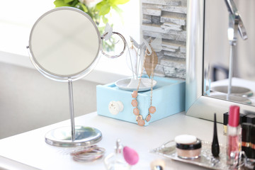 Jewelry holder with cosmetic set on light dressing table