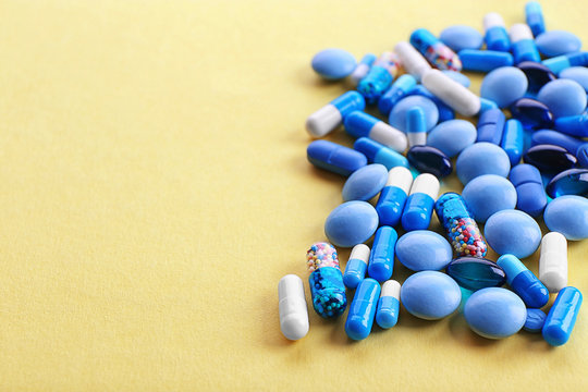 Heap of pills on yellow background