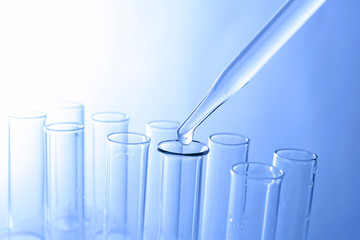Close up of a pipette dropping sample into a test tube