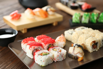 Delicious sushi set on ceramic plate and wooden boards