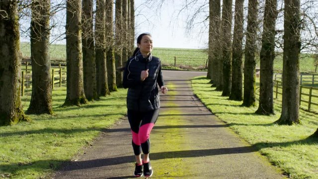  Young woman running in the countryside stops to get her breath back