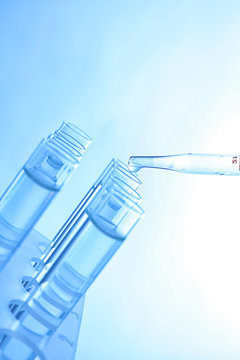 Close up of a pipette dropping sample into a test tube