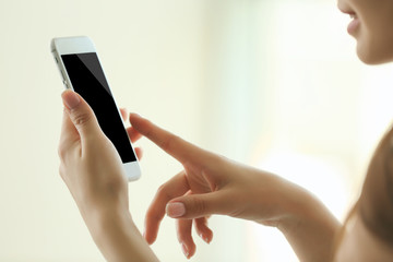 Woman listening to music on smartphone in the room