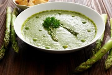 Tasty asparagus soup on table