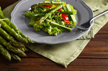 Tasty salad with asparagus and vegetables on plate