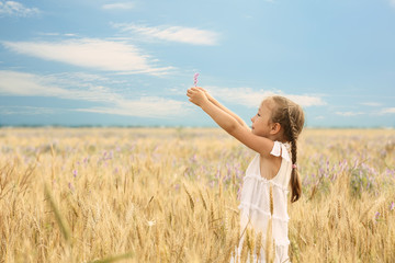 Naklejka na ściany i meble Happy little girl in the field