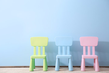 Three children chairs on blue wall background