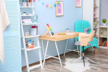 Wooden table in blue children room interior